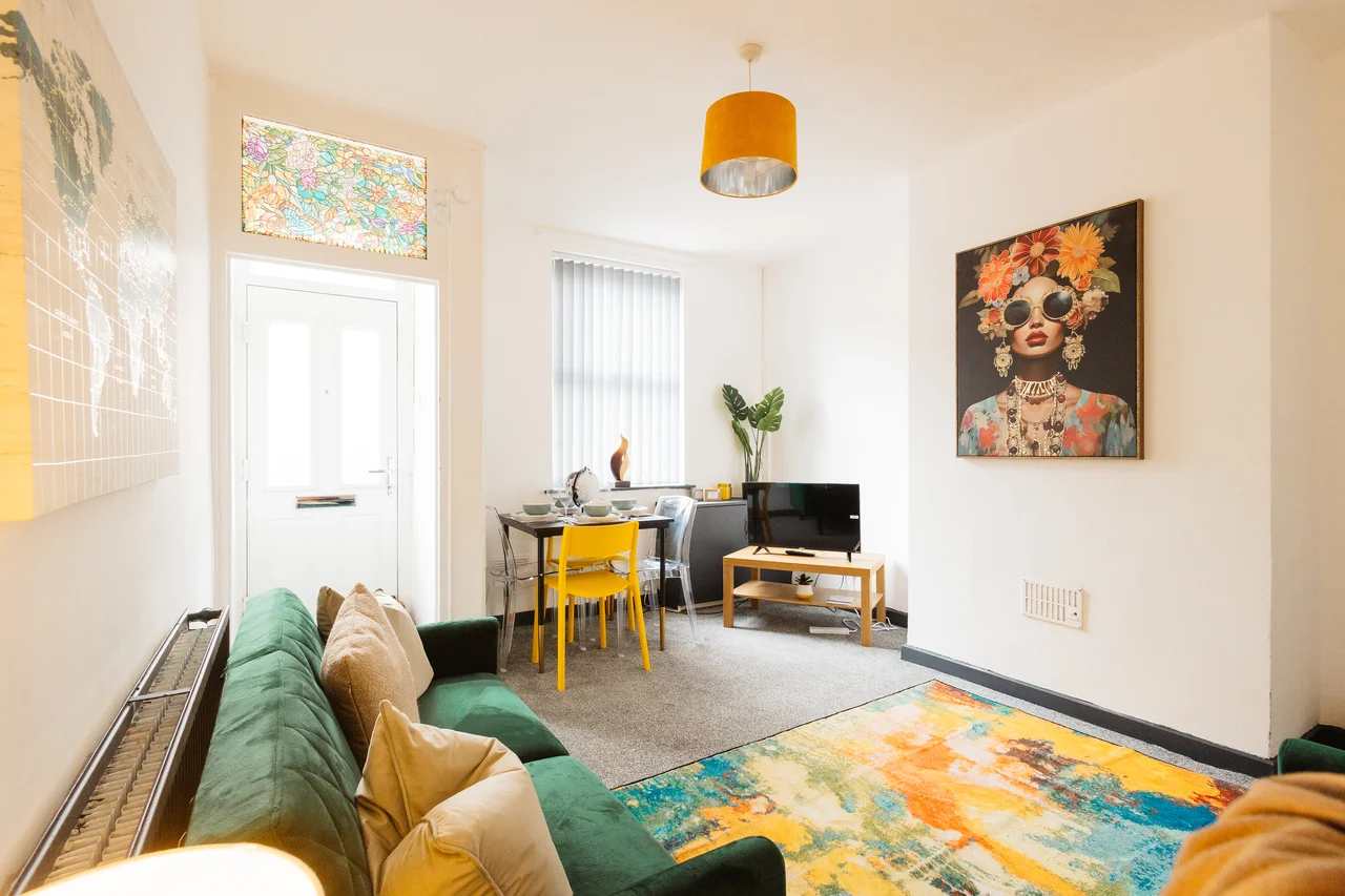 Wide view of the Widnes living room and its green sofas