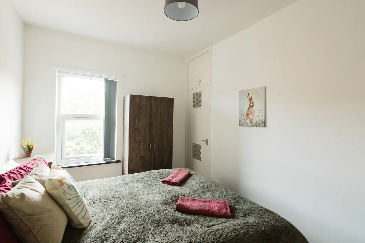 Widnes bedroom in sage and burgundy with hare artwork